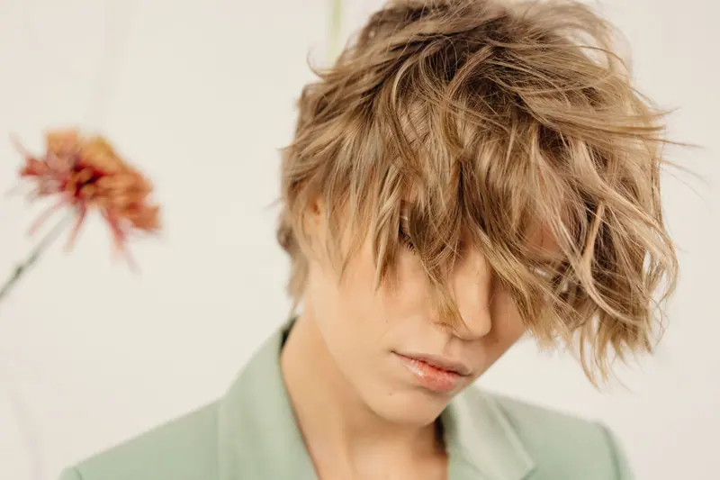 Stylish woman with tousled short hair and neutral expression.