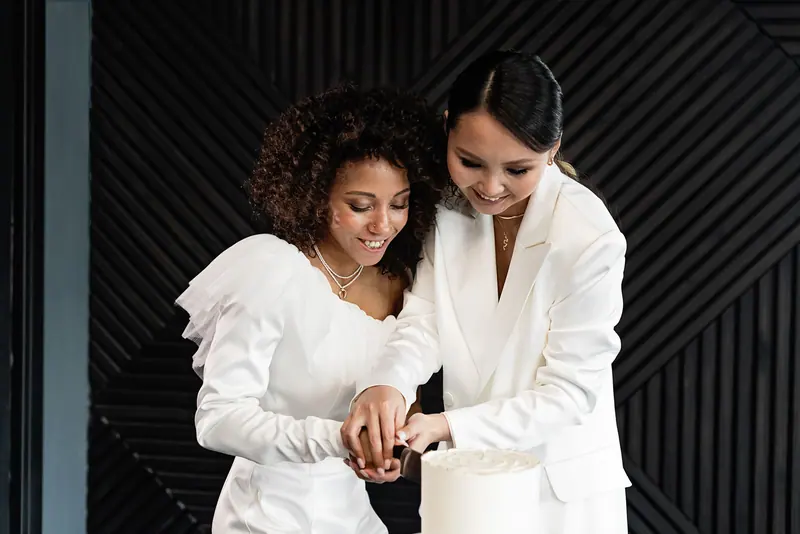 Two brides cutting their cake