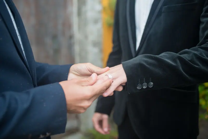 Rings exchanged between two dark suits