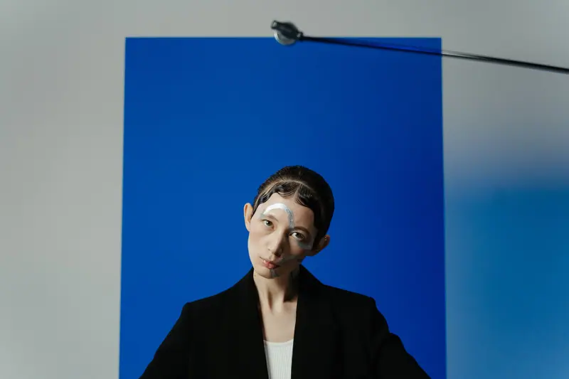 Sleek pinned hair against a cobalt panel