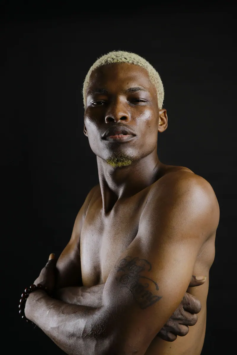 Bleached buzz cut against a black backdrop