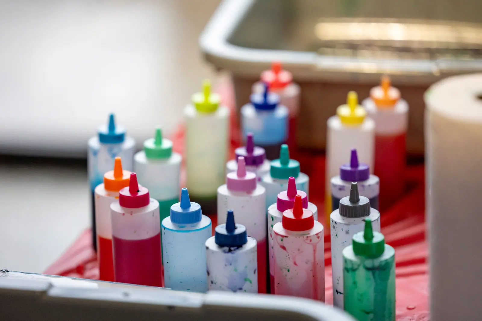 Vibrant collection of squeeze bottles with liquid pigment for artistic creations indoors.