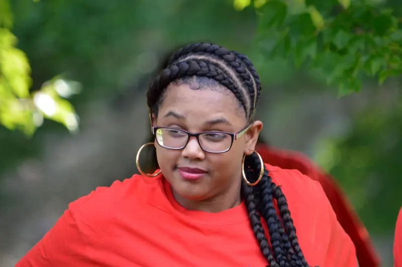 Close-up of a woman wearing glasses and braided hair outdoors