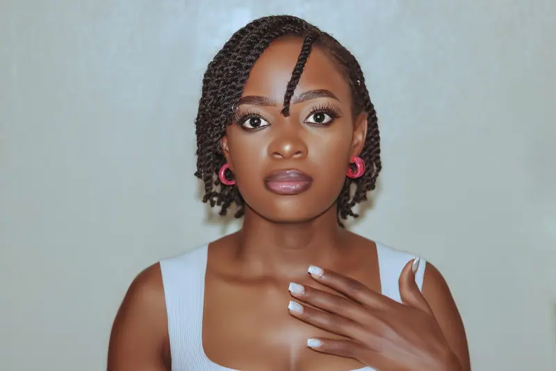 Capture of an elegant woman with braided hair and stylish earrings.