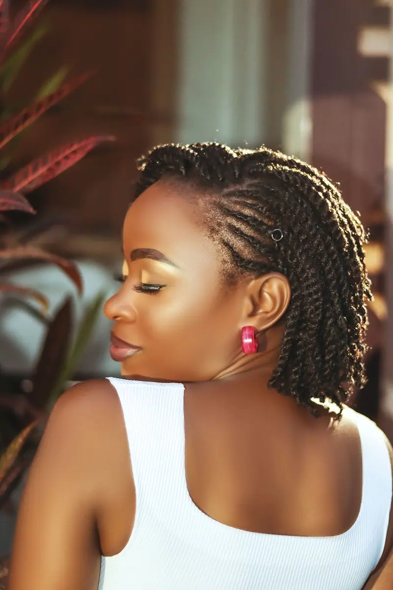 A stylish portrait of a woman with braided hair, showcasing fashion and beauty with a graceful pose.