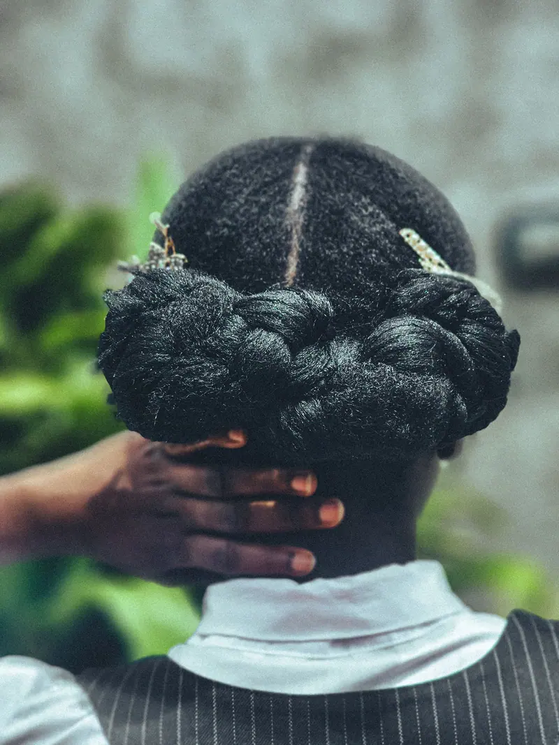 Detailed view of a stylish braided updo adorned with decorative hairpins.
