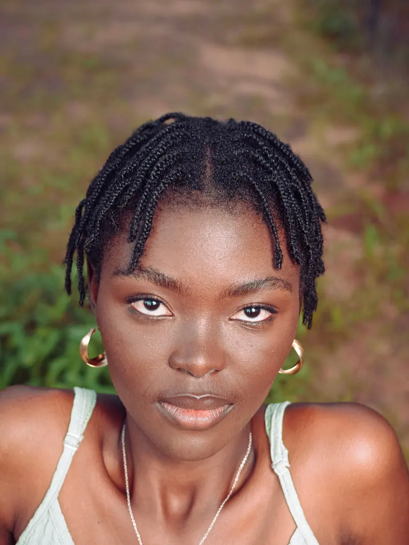 Close-up portrait of a woman with natural hairstyle and earrings in Orapa, Botswana.