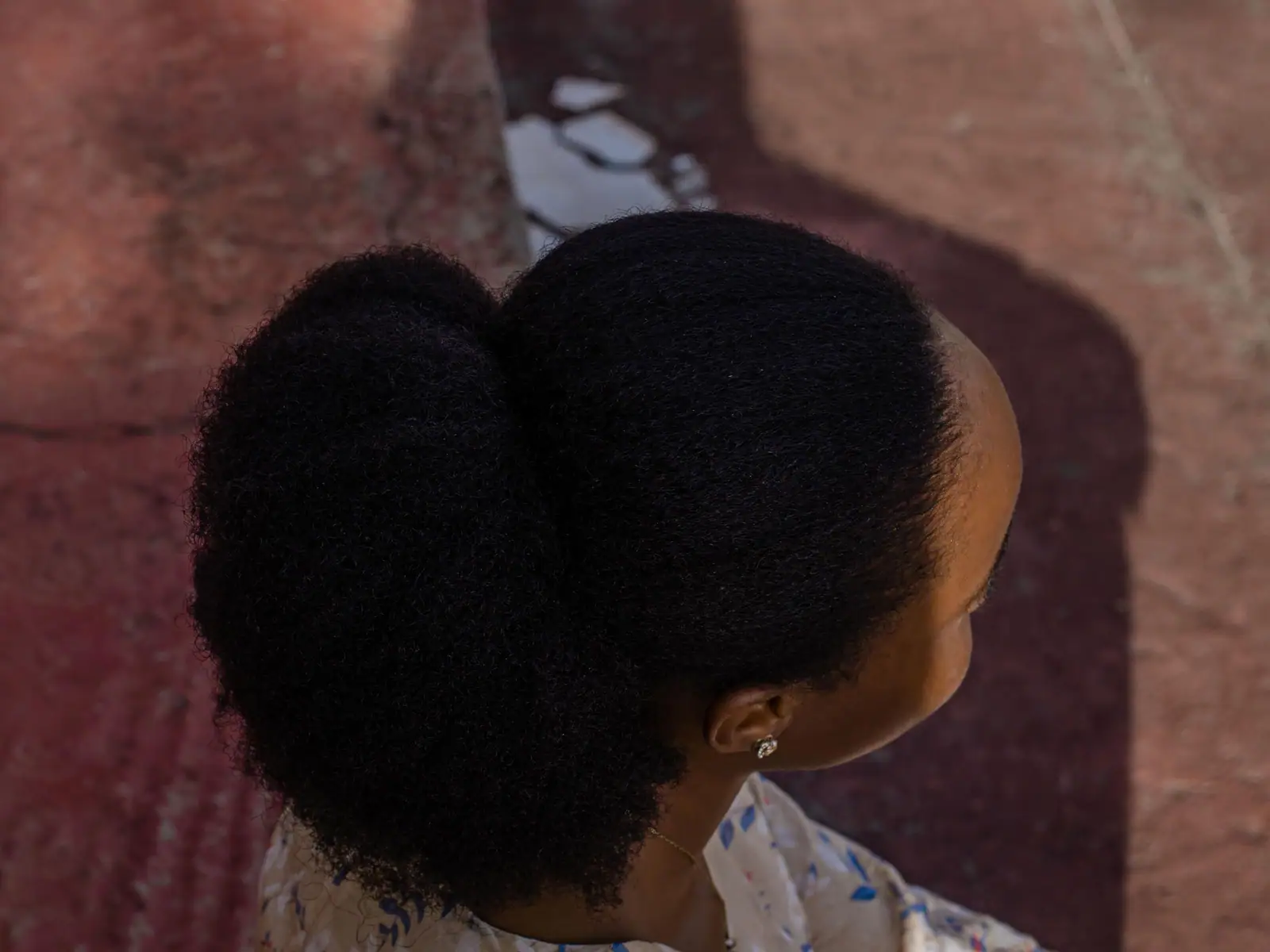 A sculpted natural-hair puff from behind, smooth edges and full coils
