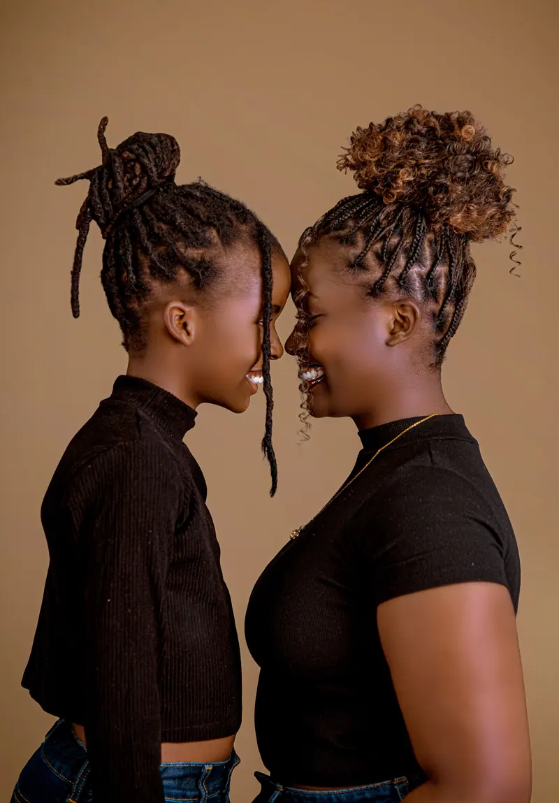 A warm portrait of two women smiling face to face, sharing a joyful moment in Rwanda.