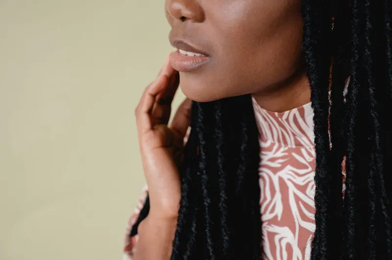 Elegant portrait of an African American woman wearing animal print attire, showcasing her dreadlocks.