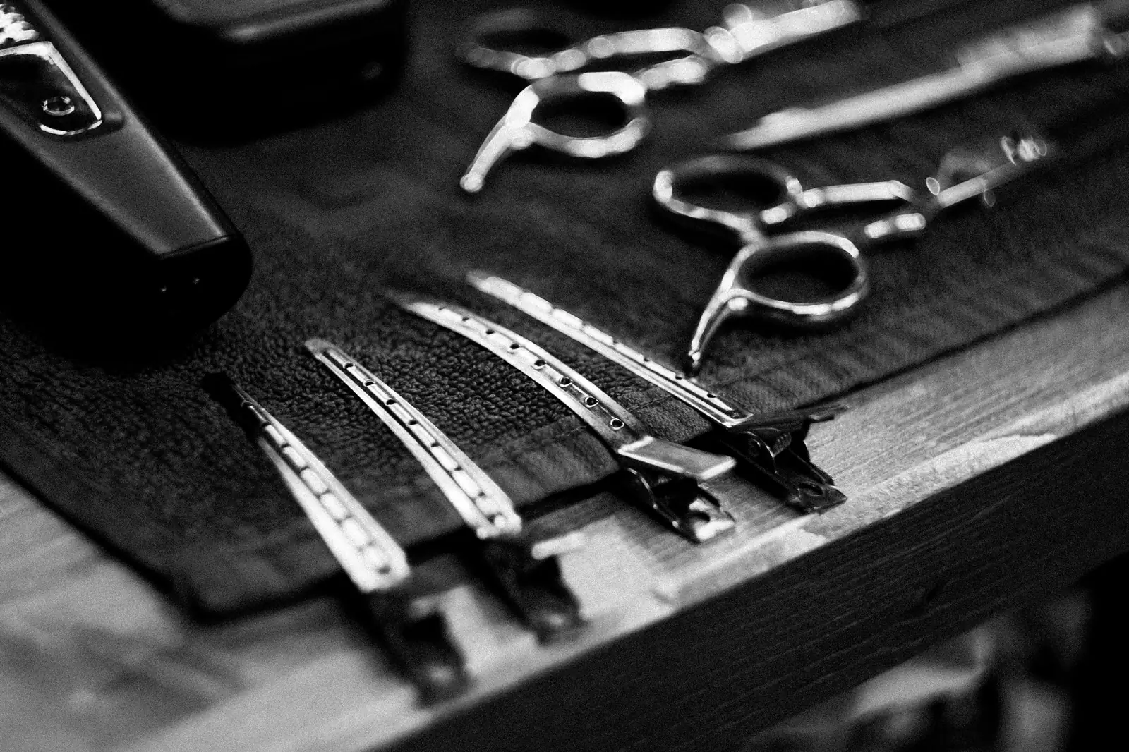 Karim Nassar’s scissors, thinning shears and comb laid out on a towel, in black and white