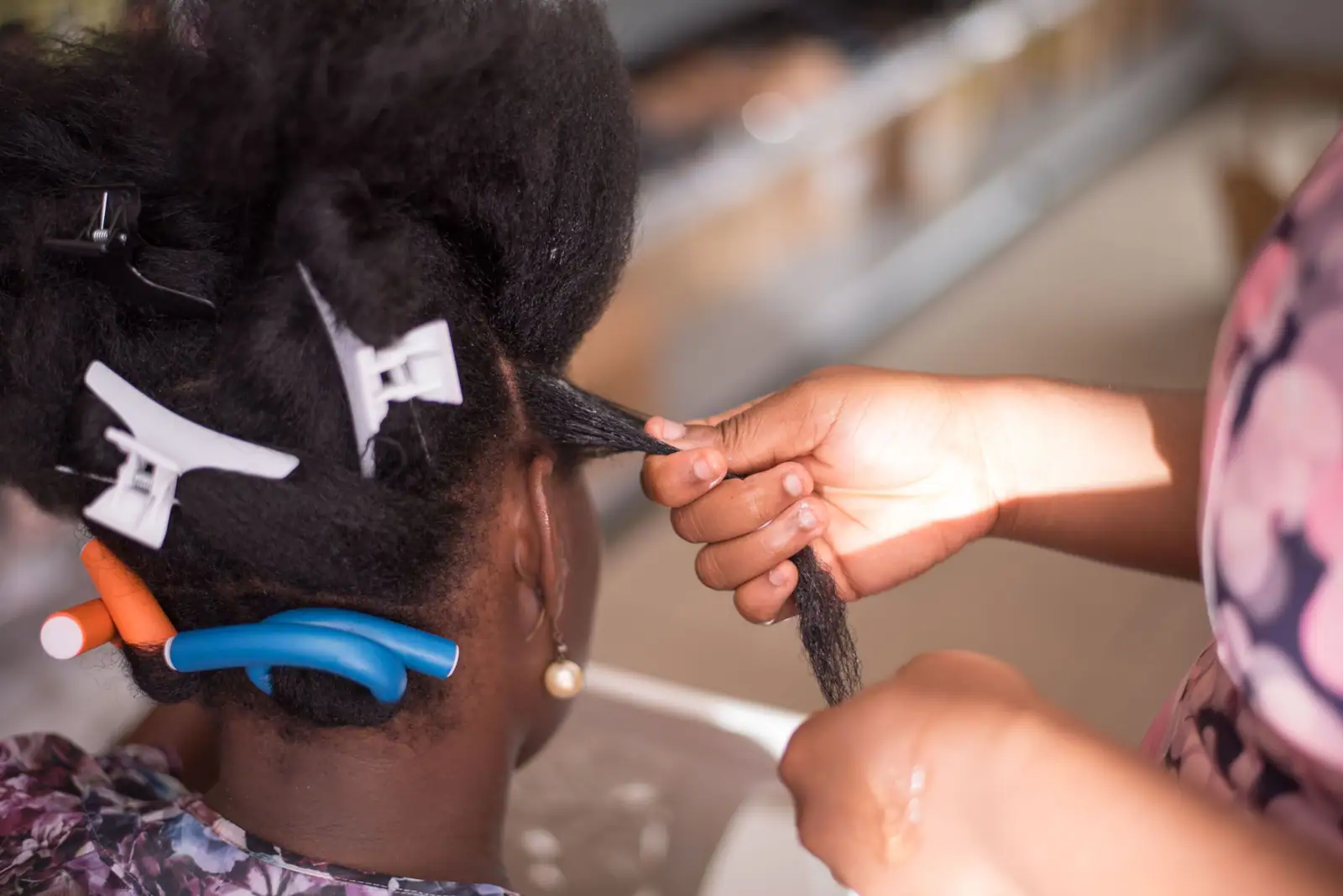 Ama’s hands sectioning and parting hair for knotless braids