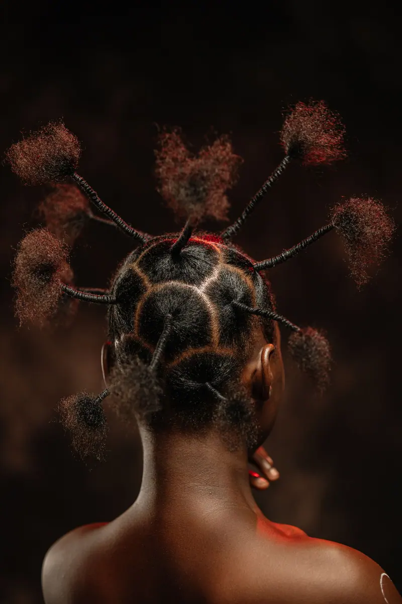 Portrait of an African woman showcasing intricate braided hairstyle from a back view in fashion photography.