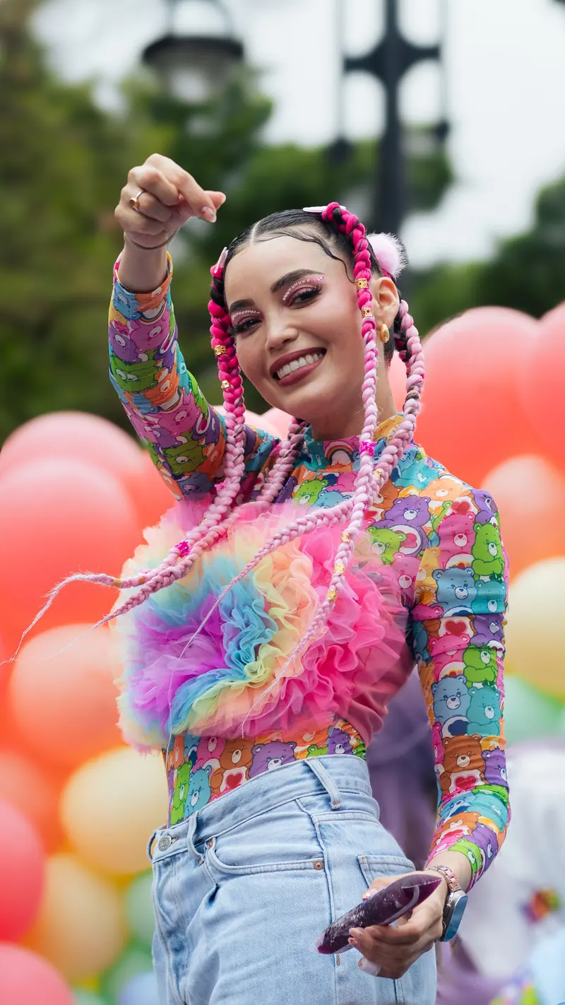 A vibrant expression of pride with colorful balloons and festive attire at an outdoor event.