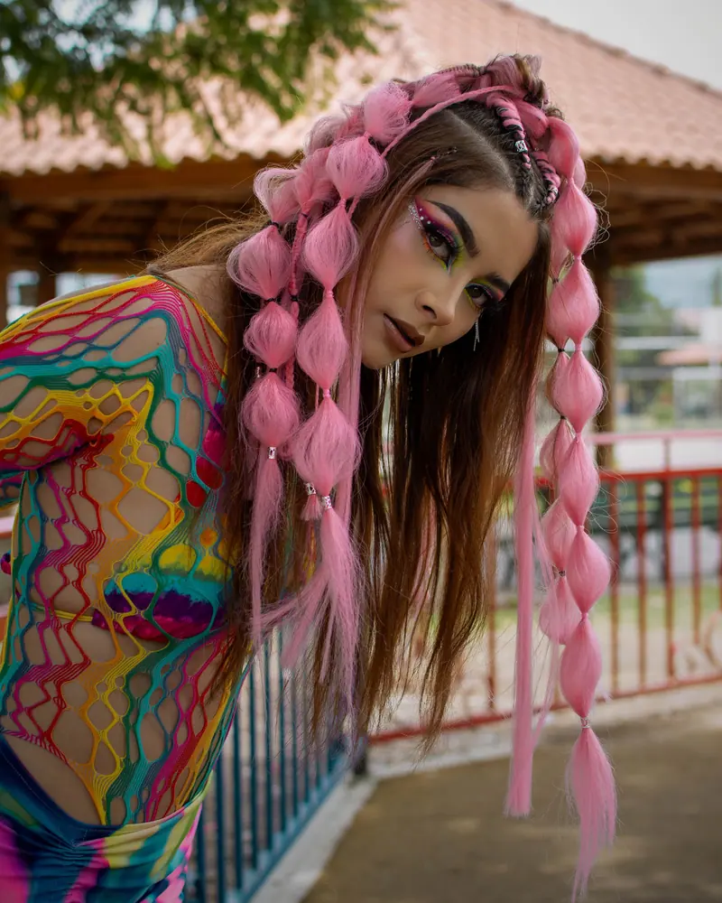 Young woman in colorful attire, bold makeup, and unique hairstyle in Cochabamba.