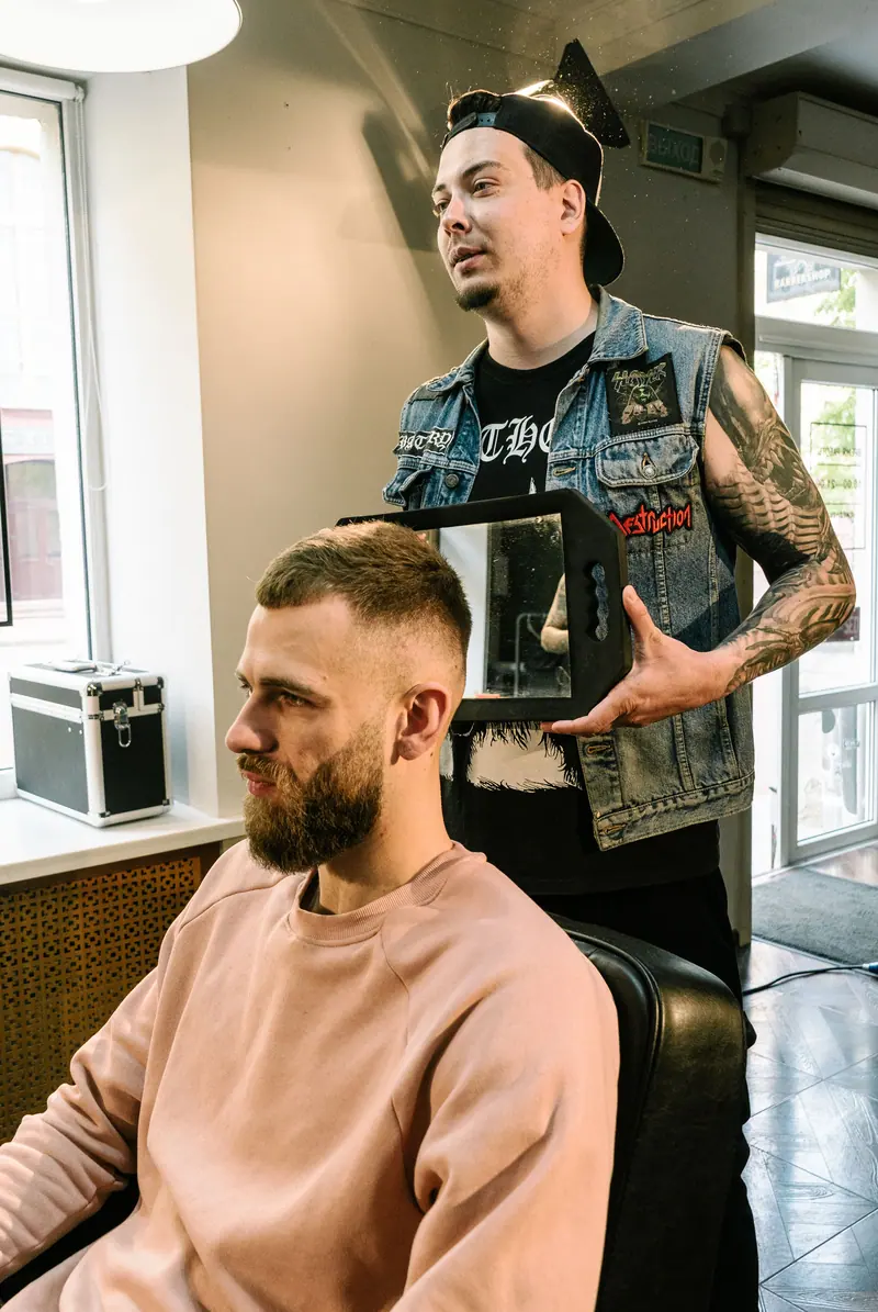 Bearded man getting a fresh haircut in a modern barbershop.