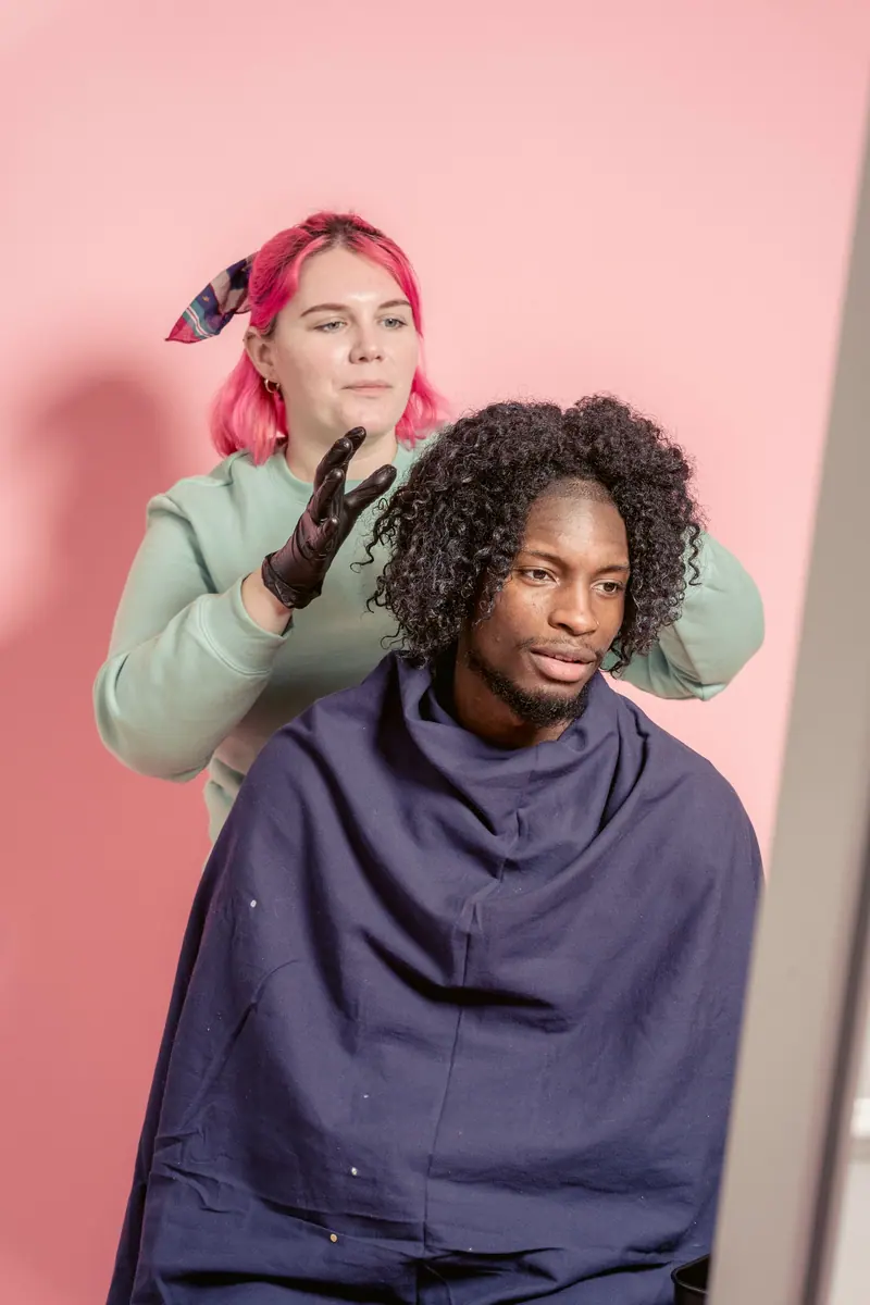 Hair stylist working on client's hairstyle in a modern salon.
