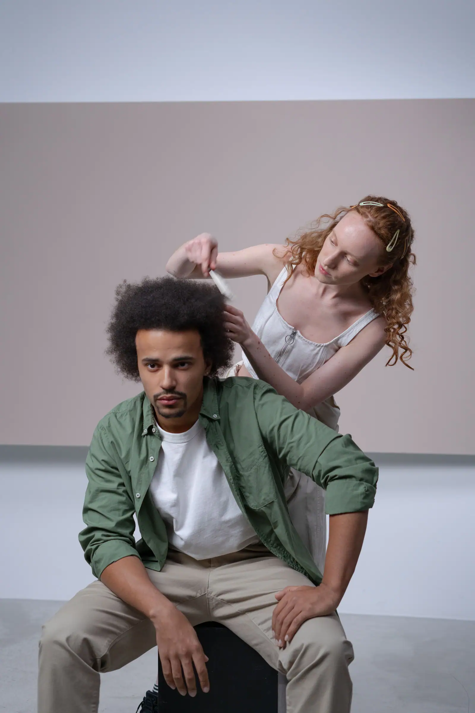 Maeve Donnelly, a red-haired curl specialist, combing out a client's afro