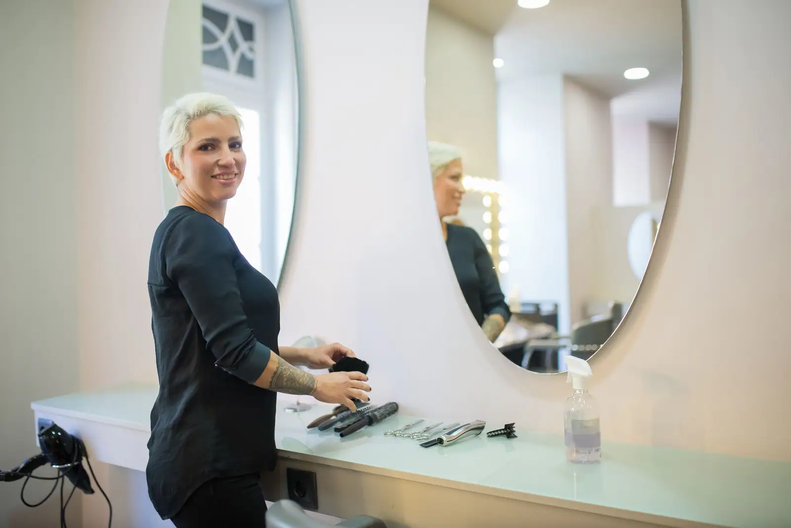 Margot, a silver-blonde stylist, setting up her bright salon station