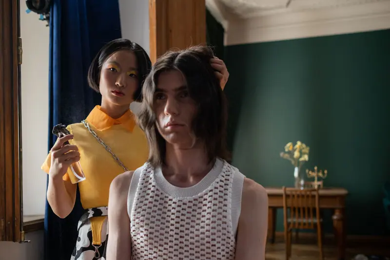 A stylish hairdressing session featuring a woman styling a man's hair in a retro-themed salon.