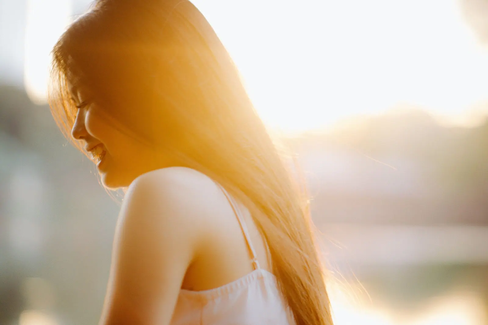 Woman with long golden hair glowing in backlit sunlight