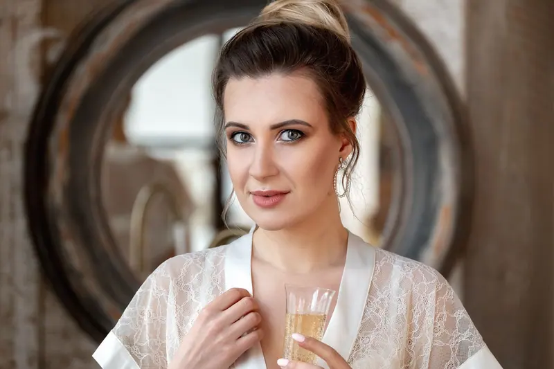 Portrait of a sophisticated woman in a lace robe with champagne, exuding elegance and style.