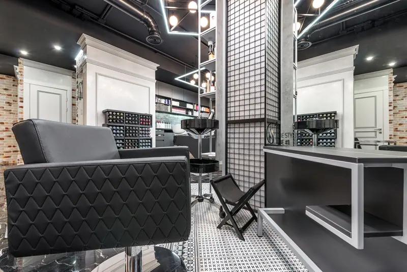 Contemporary and sophisticated barber shop interior with stylish furniture and lighting.