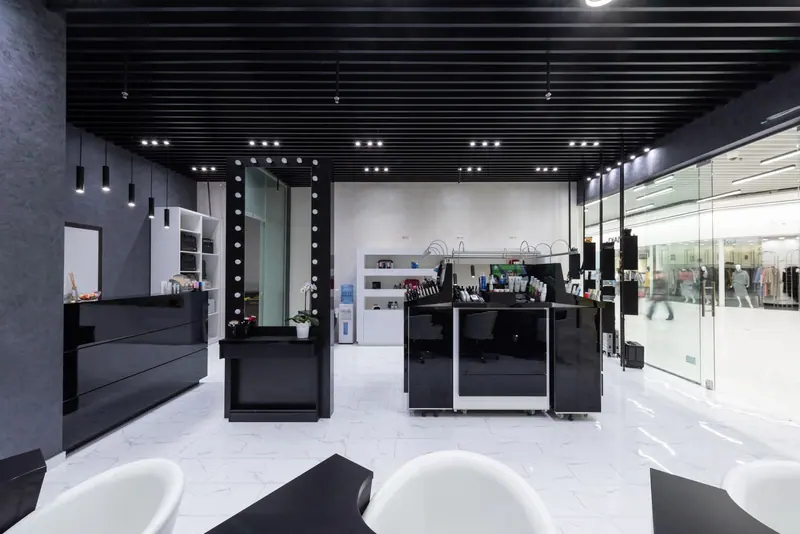 Spacious modern salon interior featuring sleek black and white decor with elegant lighting.