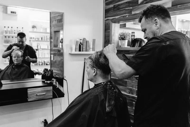 A hairdresser skillfully cuts a client's hair in a contemporary salon environment.