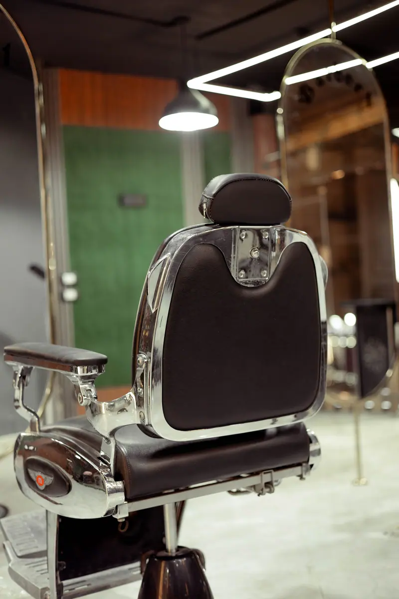 Stylish vintage barber chair in a modern salon setting, featuring chrome details and leather upholstery.