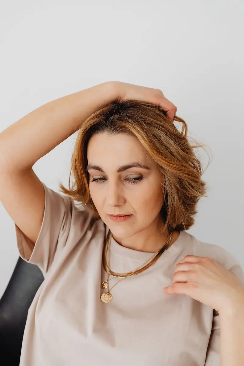 Woman running her hand through a freshly cut chin-length bob