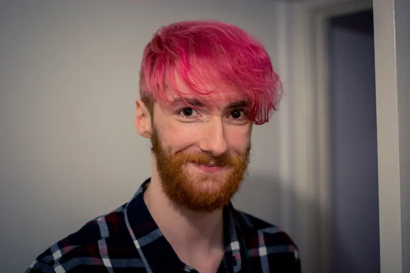 Smiling bearded man with pink hair