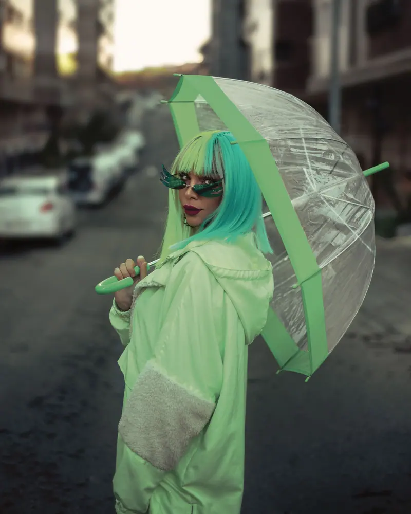 Green hair and a green umbrella on a city street