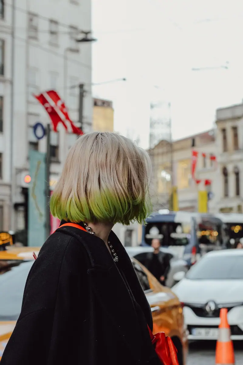 Green-tipped blonde bob on a city street