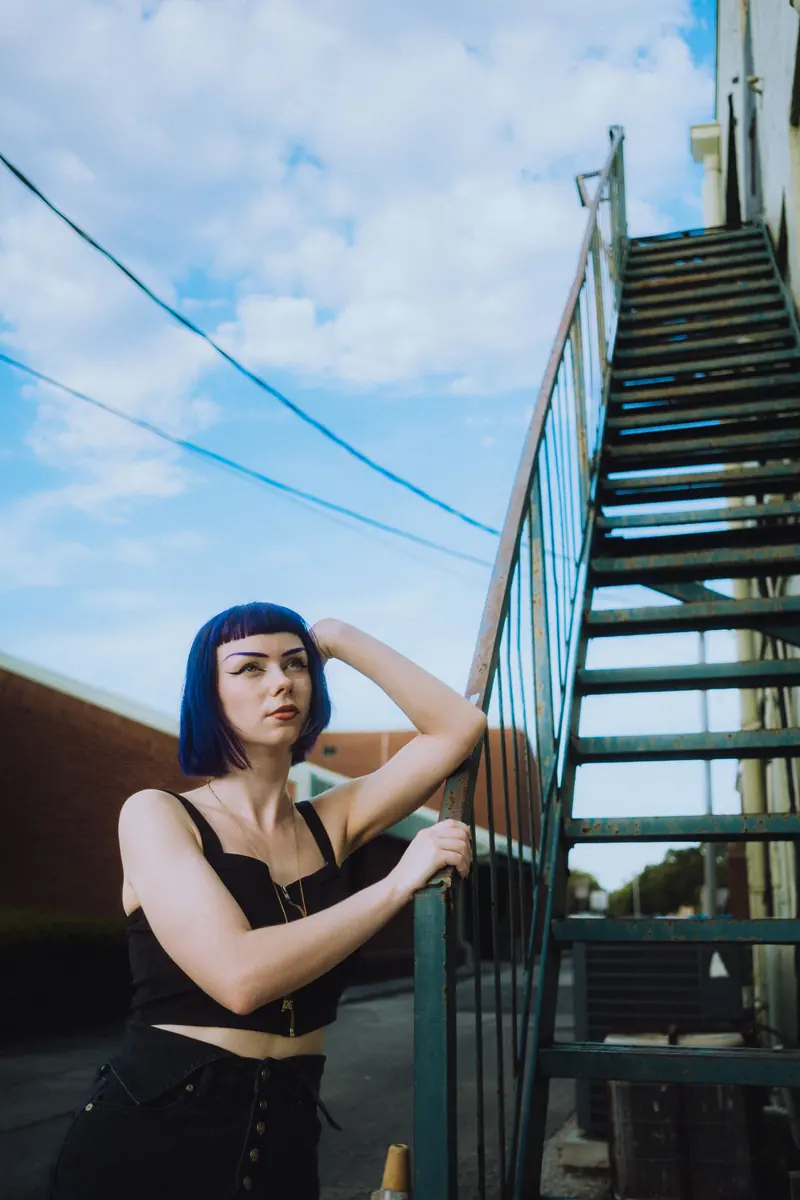 Blue hair beside an outdoor staircase