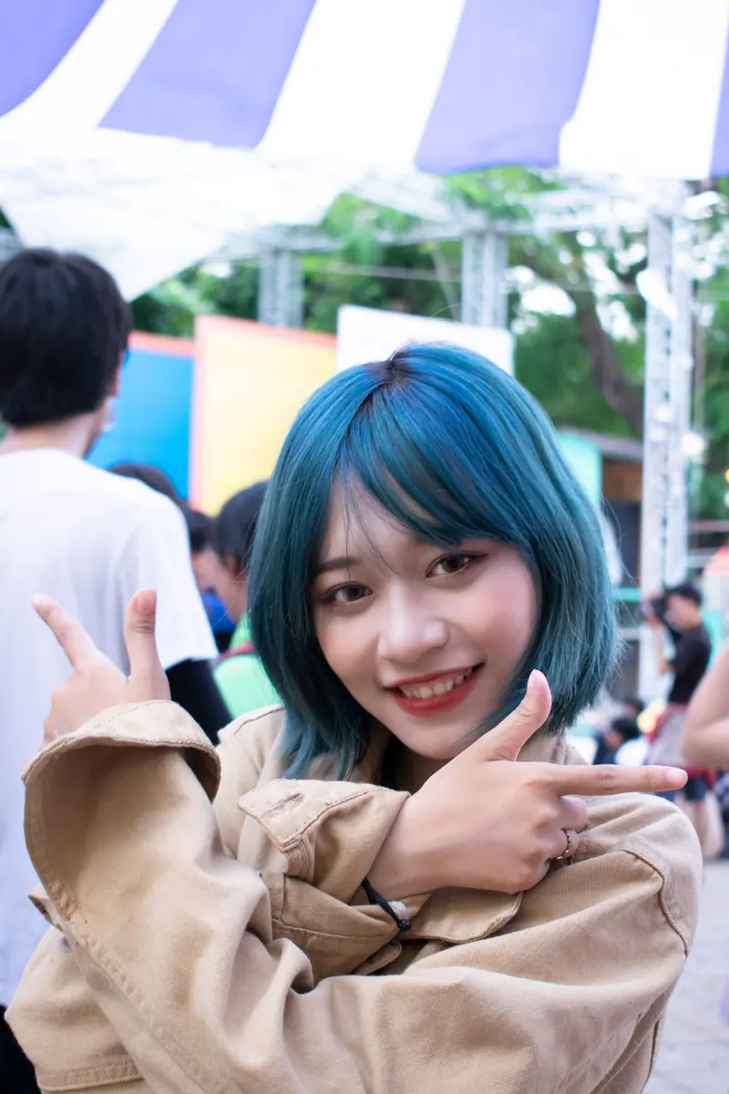 Smiling with teal hair outdoors