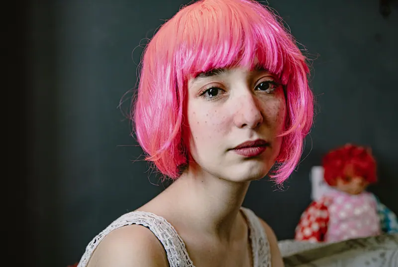 Pink bob with a heavy fringe in low light