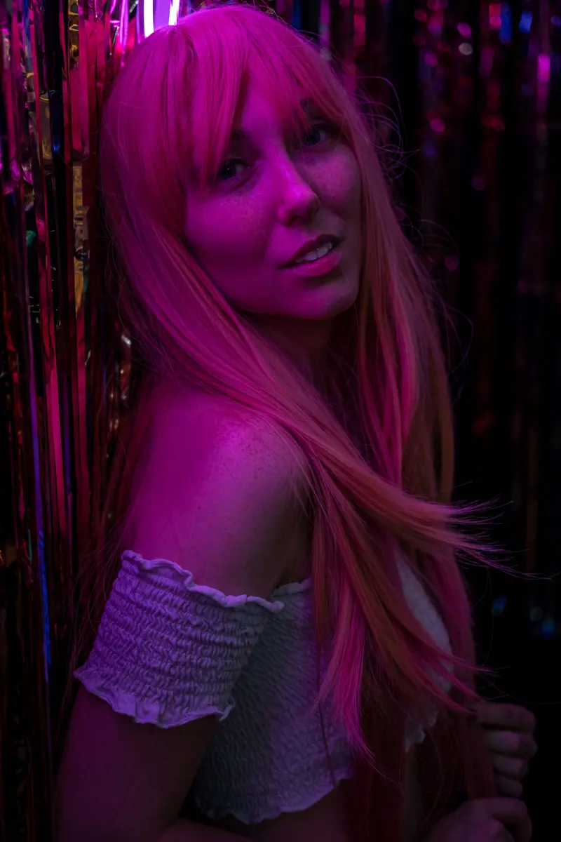 Long pink hair under a magenta glow