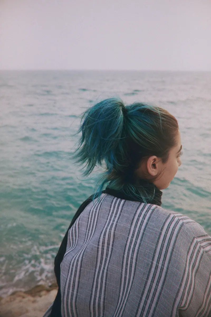 Teal ponytail by the sea