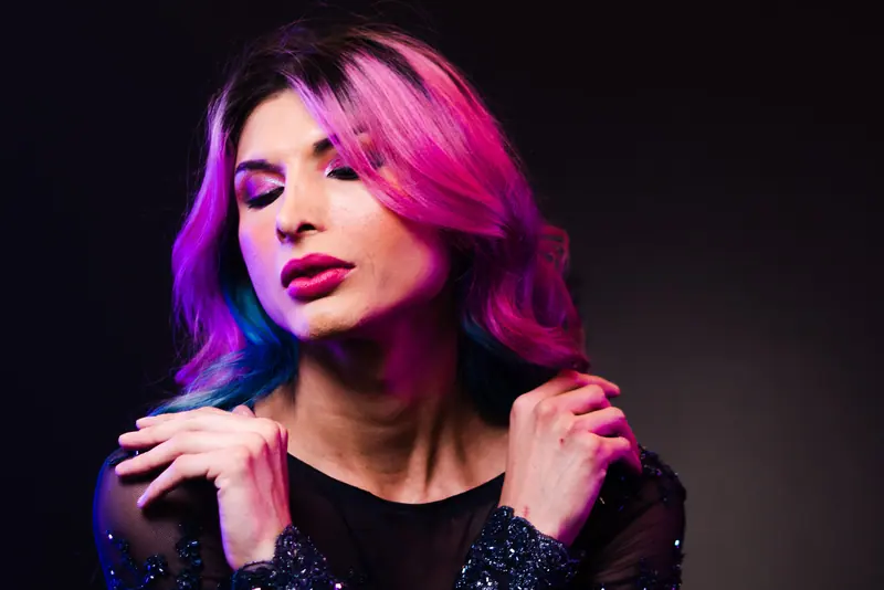 Striking portrait of a woman with vibrant dyed hair in a fashion setting.