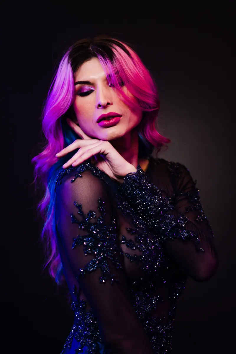 Long pink and violet hair falling over a jeweled black gown