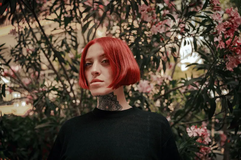 Glossy red blunt bob with a neck tattoo