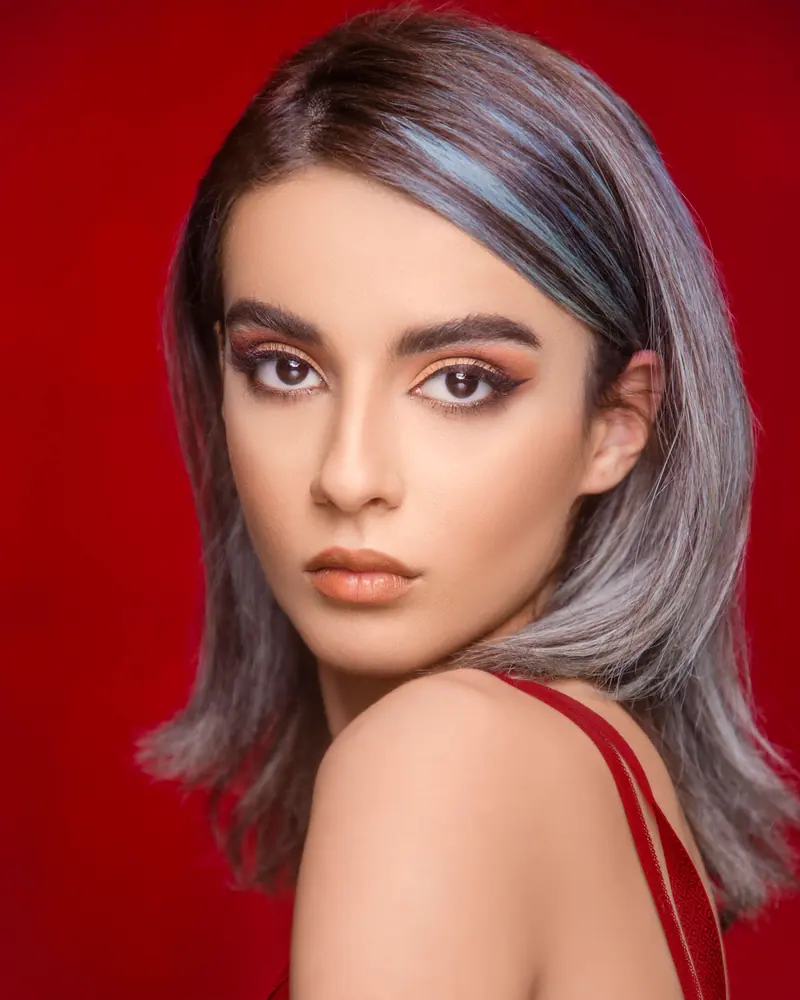 Dyed hair against a vivid red backdrop
