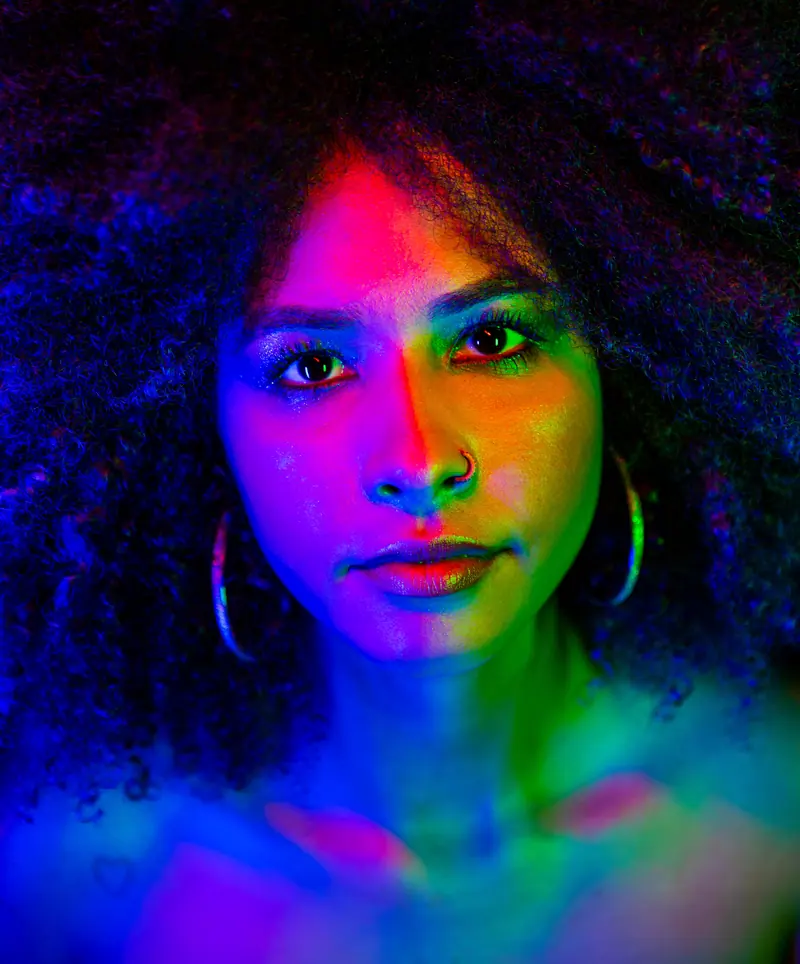 Big natural curls under rainbow neon light