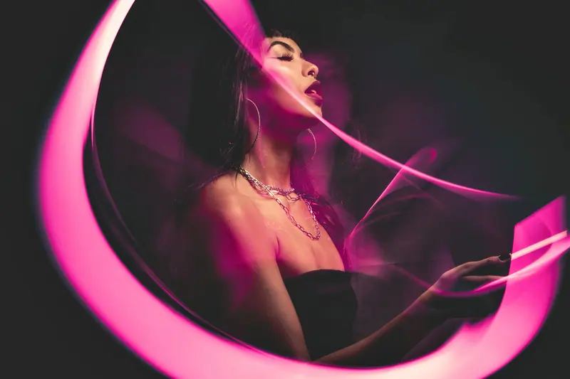 Pink light trails sweeping around a portrait