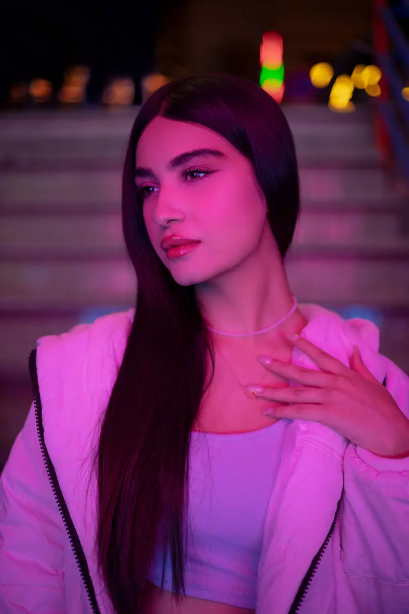 Long hair and a puffer jacket in pink light