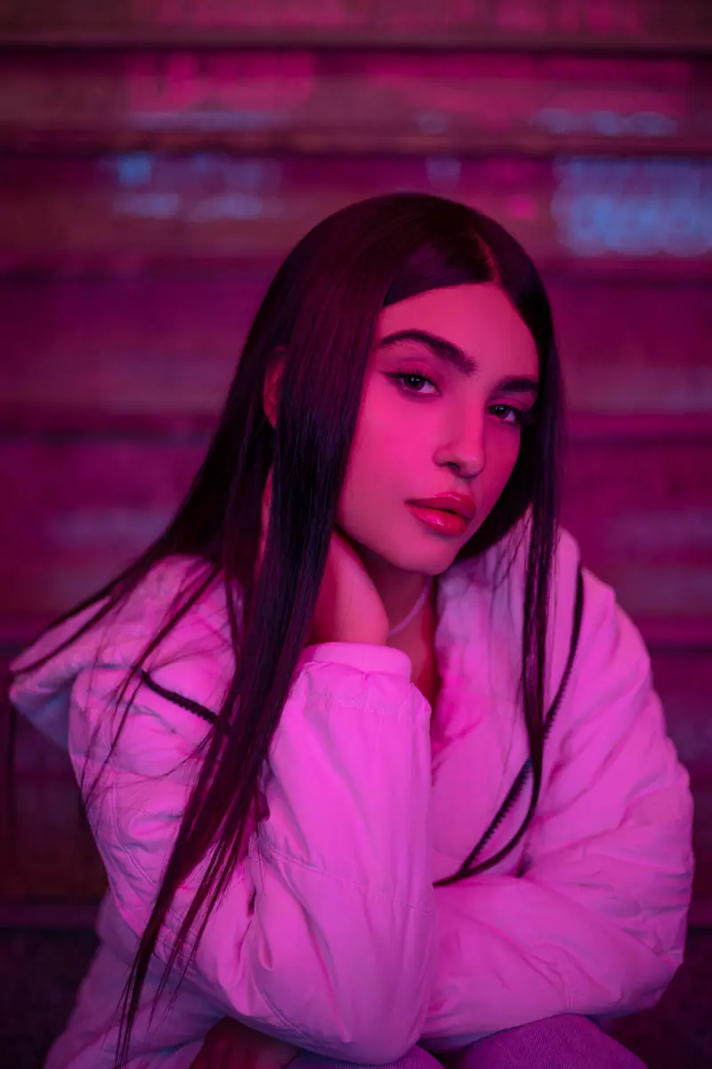 Long dark hair in a pink-lit stairwell