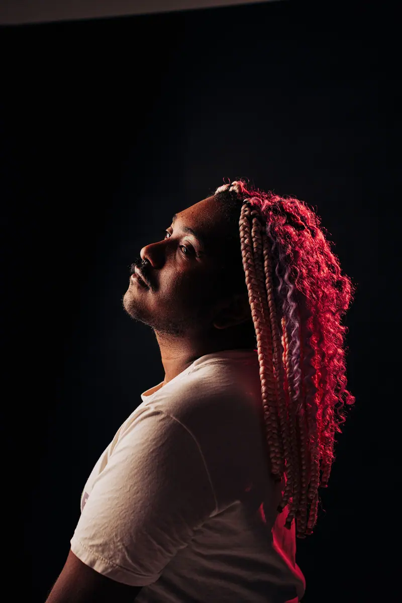 Pink braids under a single spotlight