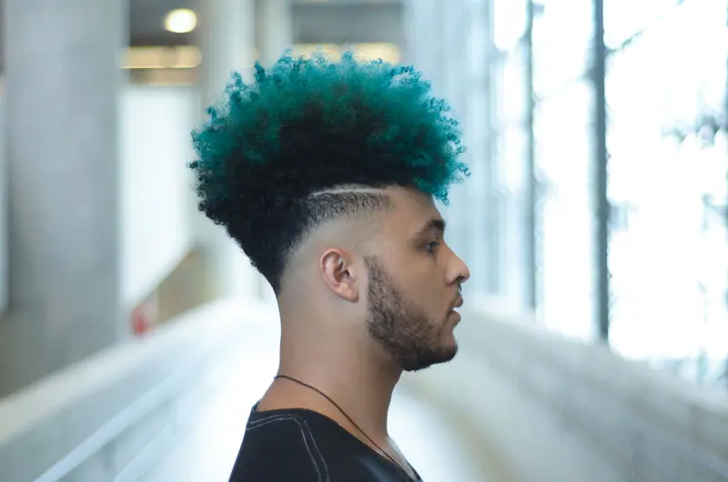 Teal-tipped curly top with a sharp fade