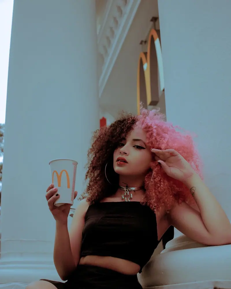 Pink and auburn curls with a tropical drink in hand